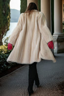 Back view of ivory faux mink coat with flared hem and textured fur surface
