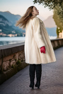Ivory faux mink coat in side profile, full length with plush stand collar