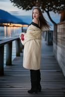 Ivory mink coat in profile with thick collar and red gloves