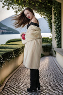 Ivory mink coat with raised collar and red gloves, long straight silhouette