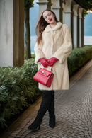 Ivory faux mink coat front view with thick collar, fitted waist, and button closure
