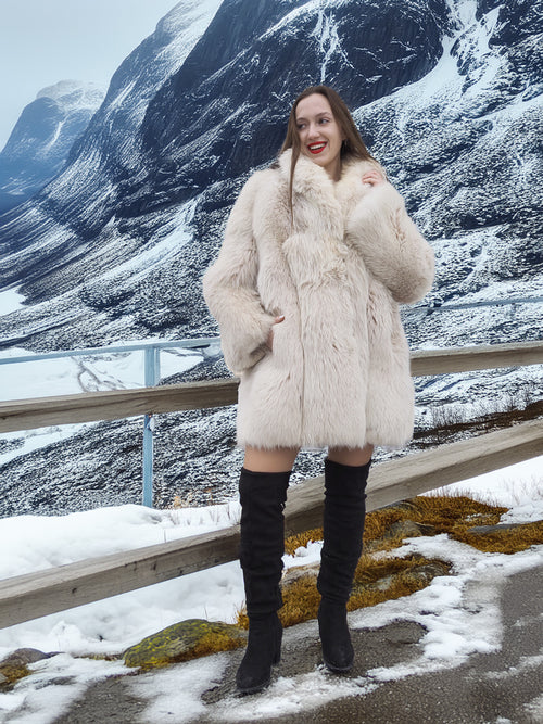 Soft Plush Blush Fox Jacket S/M styled with black boots, highlighting the coat’s warmth and elegance in a snowy outdoor setting.