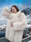 Model smiling in Soft Plush Blush Fox Jacket S/M, highlighting the coat’s soft texture and cozy fit in a snowy mountain setting.