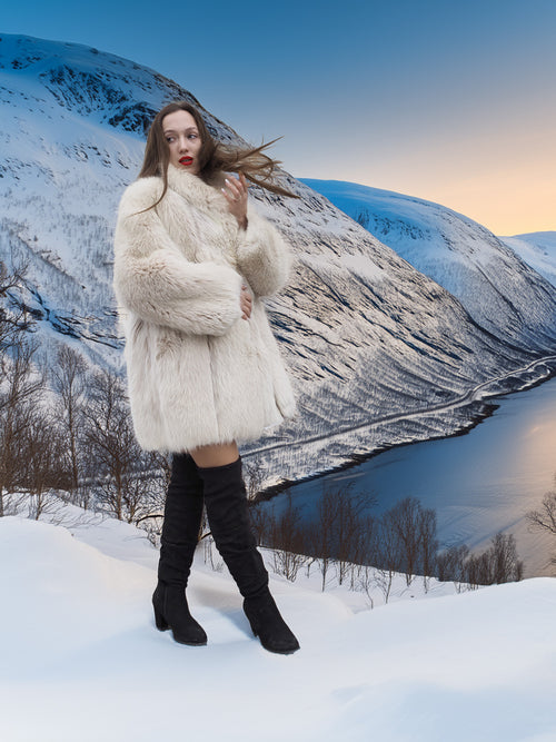 Soft Plush Blush Fox Jacket S/M featured in a snowy mountain scene, emphasizing its full fur texture and luxurious winter appeal.