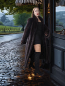 Woman in a fur coat stepping out of a vintage car on a rainy street.