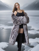 Woman wearing a fur coat in a snowy landscape with mountains.
