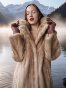 Woman wearing a fur coat with a mountainous landscape in the background