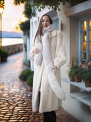 Woman in a fur coat standing on a cobblestone street with a scenic background