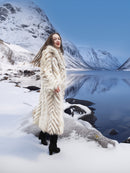 Two Tone Fox Coat Size XS/S styled in a snowy mountain scene, showcasing the coat’s plush chevron fur and elegant winter silhouette.