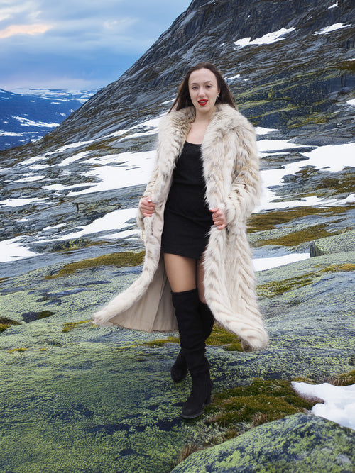 Two Tone Fox Coat Size XS/S styled over a black outfit in a snowy mountain setting, emphasizing luxury fur fashion and chevron design.