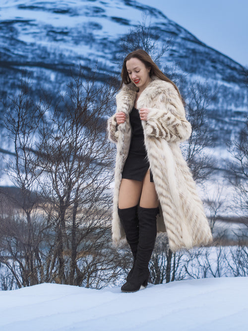 Model in Two Tone Fox Coat Size XS/S walking on snow, highlighting the coat’s chevron fur and elegant full-length silhouette.