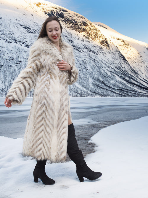 Two Tone Fox Coat Size XS/S styled in a snowy landscape, highlighting the coat’s chevron fur pattern and elegant silhouette.