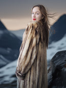 Woman wearing a fur coat with a mountainous background