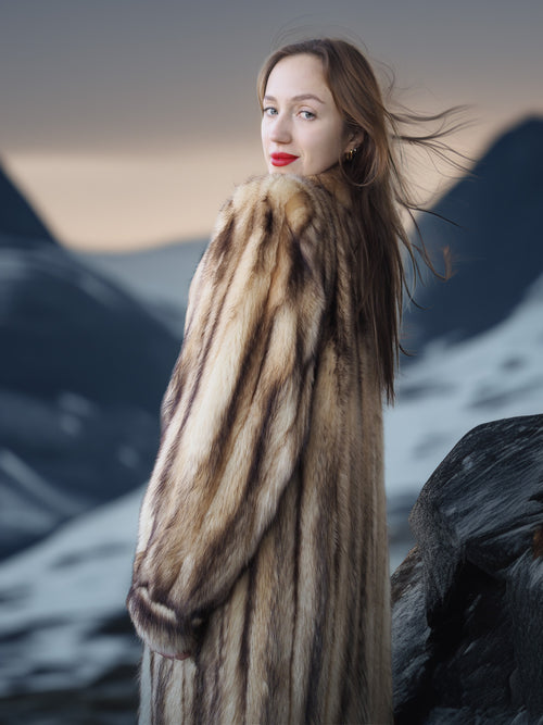 Woman wearing a fur coat with a mountainous background