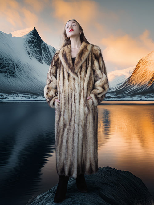 Woman in a fur coat standing in front of a mountain lake with a scenic background