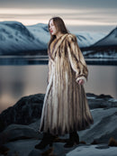 Woman in a fur coat standing in a snowy landscape with mountains in the background