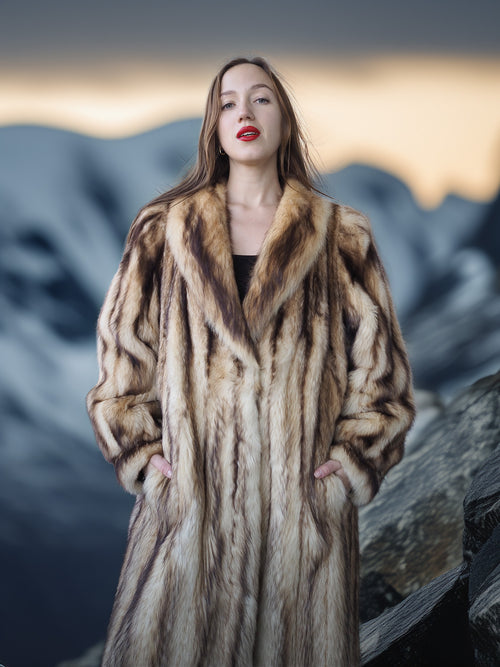 Woman wearing a fur coat with a mountainous background