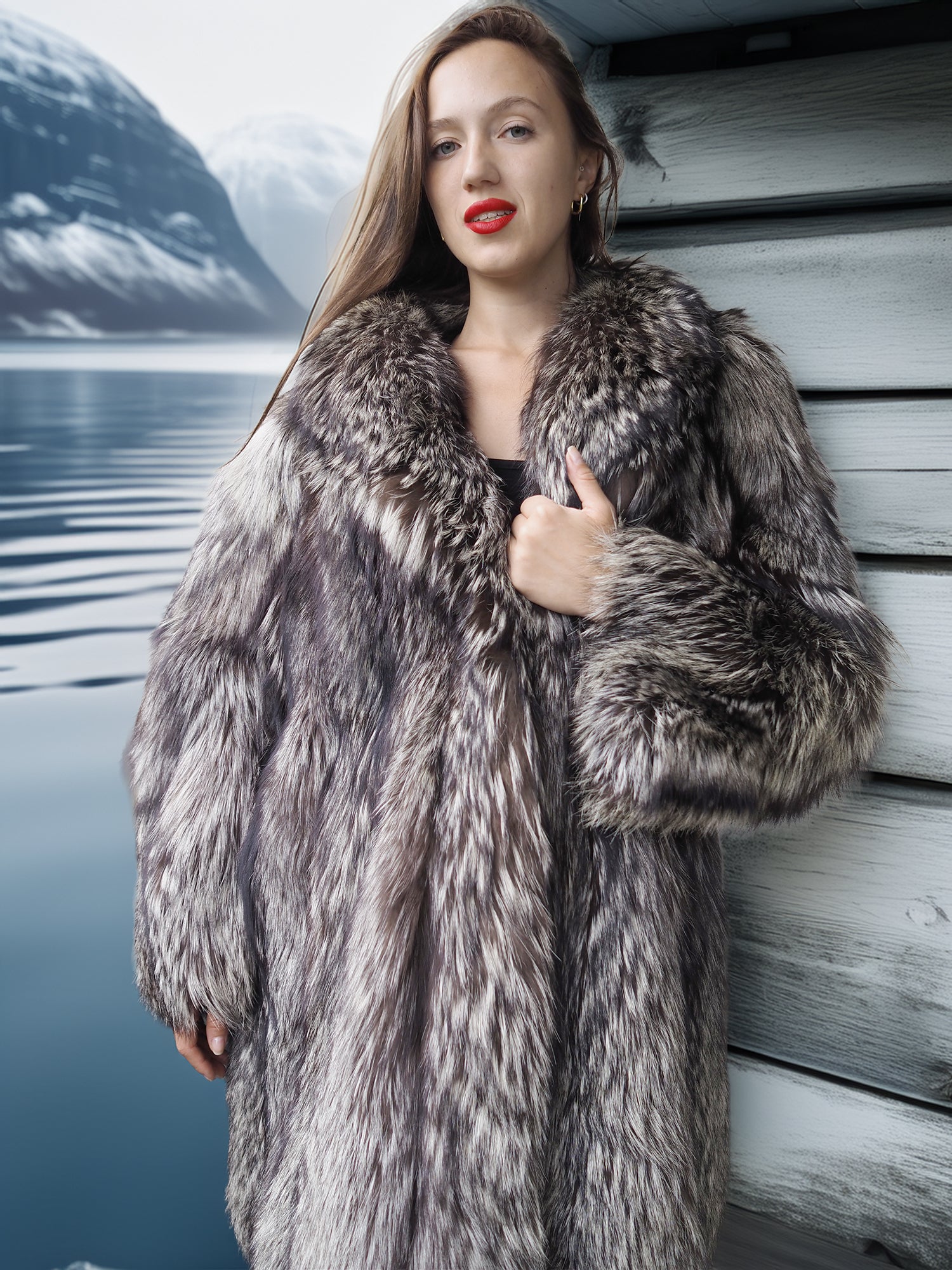 Woman wearing a fur coat by a body of water with mountains in the background