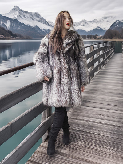 Woman in a fur coat standing on a wooden pier with mountains and a lake in the background