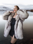 Woman wearing a fur coat standing in a snowy landscape