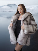 Woman wearing a fur coat with a scenic background
