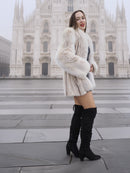 Model in Brown Cross Mink Fur Coat Jacket S with Blush Fox Trim standing in front of cathedral, highlighting its premium fur and winter appeal.