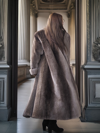 Person wearing a long fur coat standing in an ornate hallway