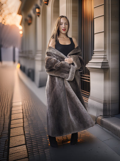 Woman in a long fur coat standing on a city street at night.