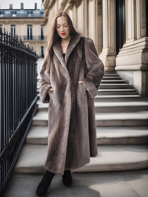 Woman wearing a long brown coat standing on steps in an urban setting