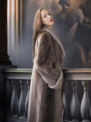 Woman in a long fur coat standing in an elegant interior setting