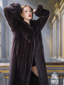 Woman wearing a long dark fur coat in an elegant interior setting