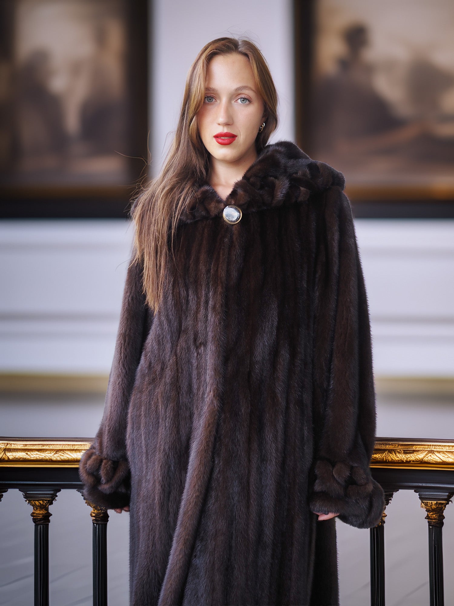 Woman wearing a dark fur coat in an elegant interior setting