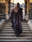 Person in a long coat walking up a set of stairs in an urban setting