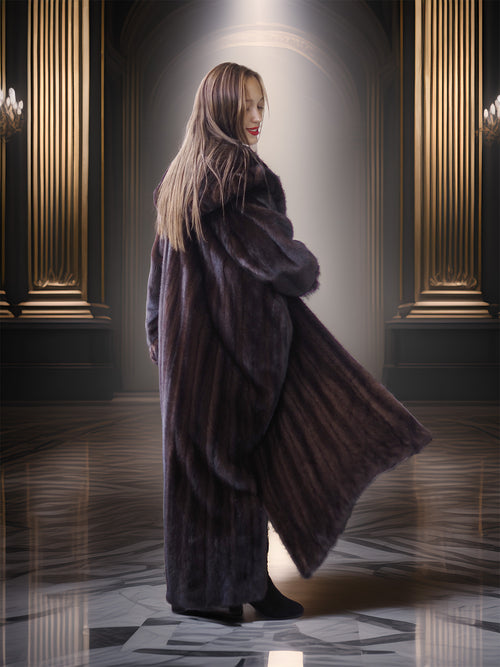 Woman in a long fur coat standing in an elegant room with chandeliers.