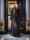 Woman wearing a long fur coat in an elegant interior setting