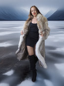 Woman wearing a fur coat standing on a snowy landscape with mountains in the background