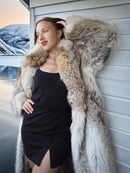 Woman wearing a fur coat standing against a snowy landscape