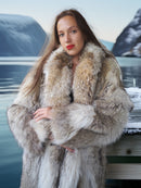 Woman wearing a fur coat with a scenic background