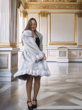 Woman wearing a fur coat in an ornate room with gold accents