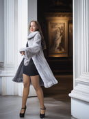 Woman in a fur coat standing in an elegant interior setting