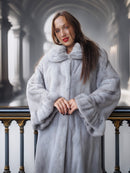 Woman wearing a light gray fur coat in an elegant interior setting
