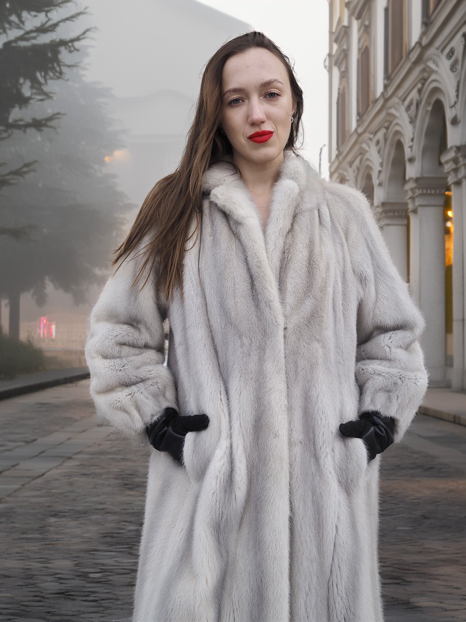 Close-up of Sapphire Grey Mink Fur Coat S Petit Excellent with hands in pockets, highlighting plush texture and tailored fit.