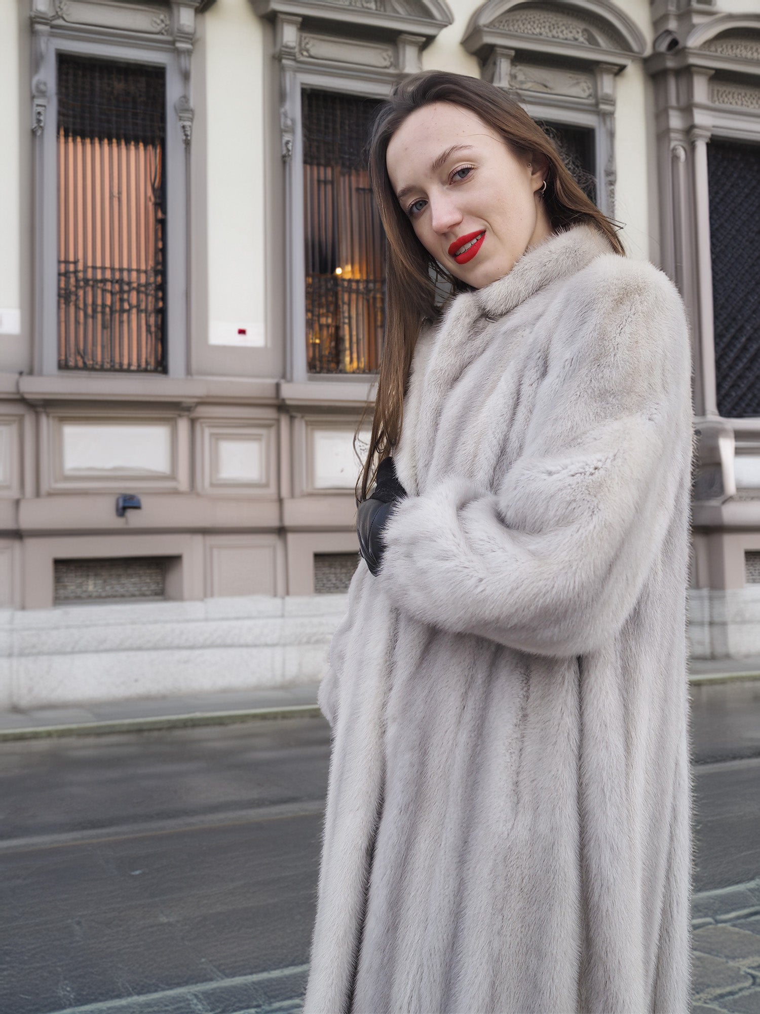 Side view of Sapphire Grey Mink Fur Coat S Petit Excellent, styled with red lipstick and black gloves for a bold winter look.