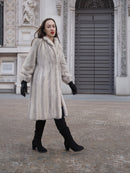 Elegant winter fashion with Sapphire Grey Mink Fur Coat S Petit Excellent, styled with black suede boots and gloves in a historic plaza.