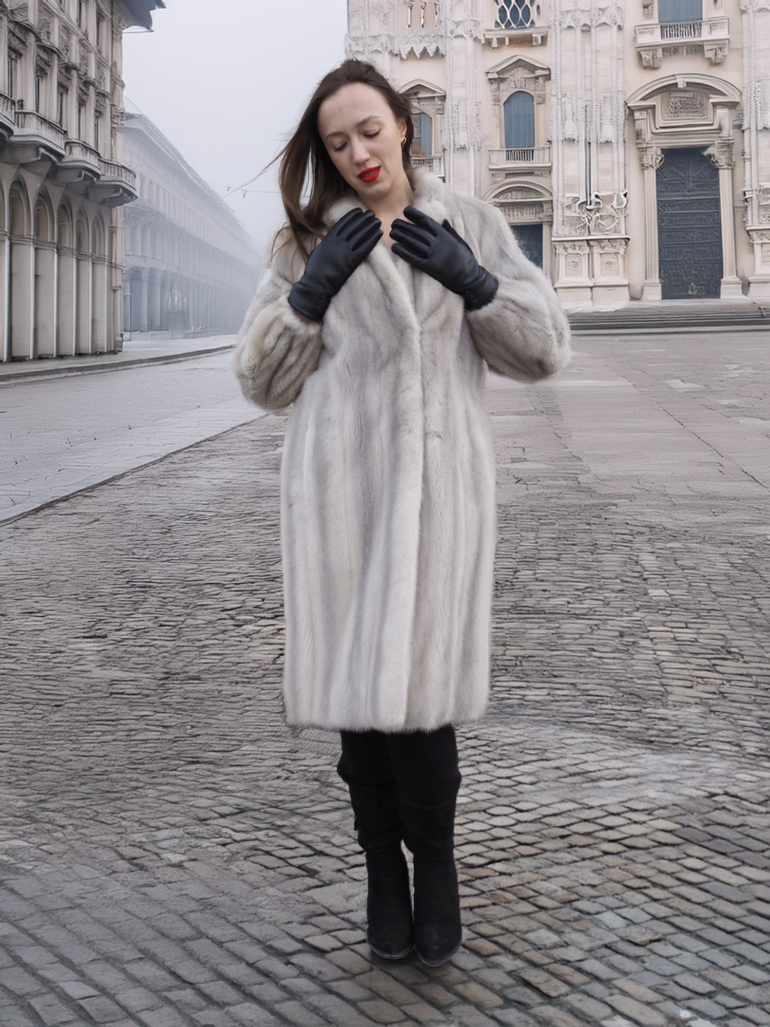 Model adjusts gloves while wearing Sapphire Grey Mink Fur Coat S Petit Excellent, ideal for sustainable and elegant winter fashion.