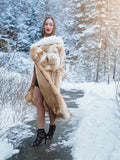 Coyote fur coat with white fox trim on snowy path