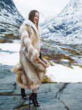 Coyote fur coat with white fox trim in winter landscape