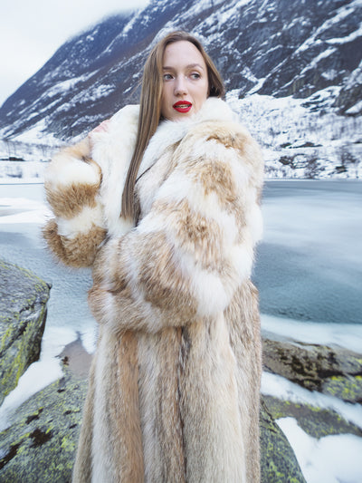 Coyote fur coat with white fox trim by icy river