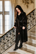 Woman in a black coat standing on a decorative staircase