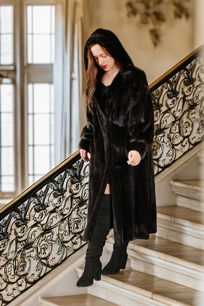 Woman in a black coat standing on a decorative staircase